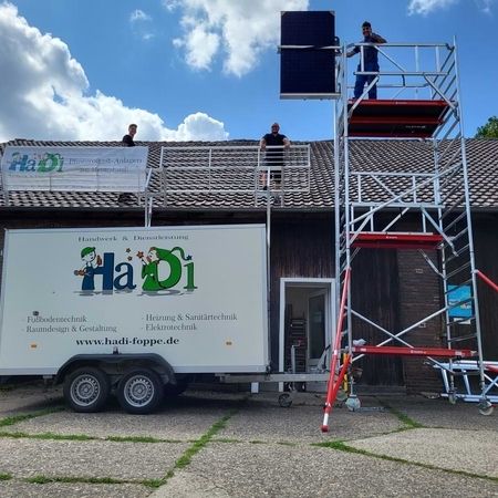 Ein Mann auf einer Leiter bei der Installation einer PV Anlage